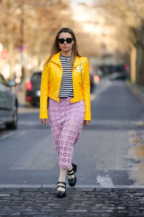 paris, france march 01 julia comil wears black sunglasses, a silver large chain necklace from tiffany, a black and white striped print pattern t shirt, a yellow shiny varnished leather jacket from courreges, pale pink cut out pattern midi tube skirt, pale yellow tights, black shiny leather belted block heels ballerinas , outside cecilie bahnsen, during paris fashion week womenswear fall winter 2023 2024, on march 01, 2023 in paris, france photo by edward berthelotgetty images