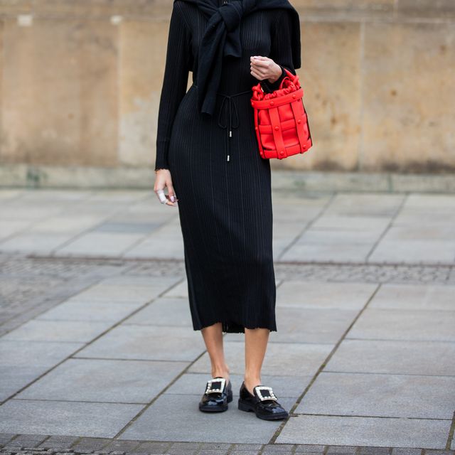 berlin, germany   march 15 mandy bork is seen wearing black dress tmosca, loafers roger vivier, jumper worn over shoulders akret, sunglasses versace, red bucket bag ferragamo during berlin fashion week on march 15, 2022 in berlin, germany photo by christian vieriggetty images