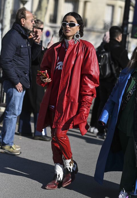 paris, france   march 08 a guest is seen wearing a red coat red pants, cowboy boots and diamond silver earrings outside the chanel show during paris fashion week aw 2022 on march 08, 2022 in paris, france photo by daniel zuchnikgetty images
