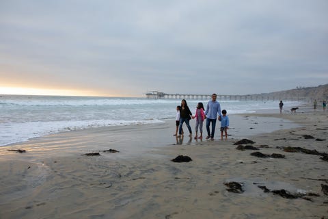 the author walks along a beach with her ex husband and their three children