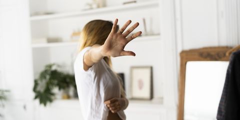 Abuse and violence against women, woman raising hand at home