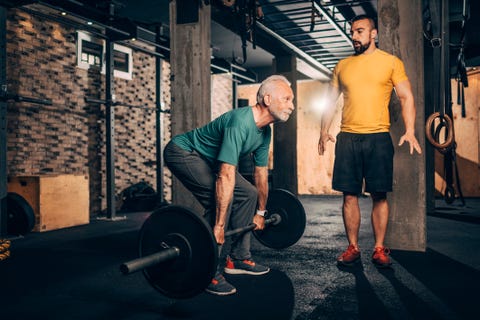 Trending Medical and health breaking news Active senior male doing a deadlift exercise with his personal coach monitoring him in a gym gym Trending Medical and health breaking news active senior male doing a deadlift exercise with his personal coach monitoring him in a gym gym