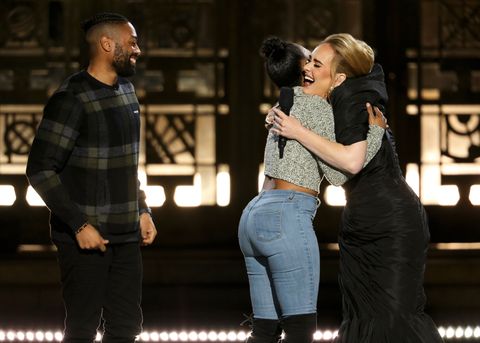 adele hugging a couple onstage