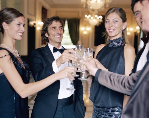 Adults wearing formal attire, toasting champagne glasses