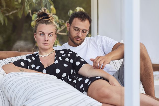 affectionate young couple relaxing on sofa in back yard