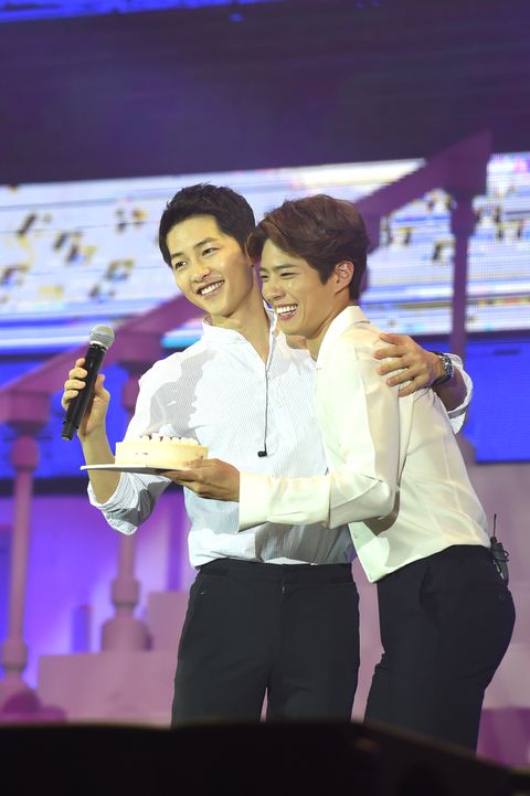 south korean actor song joong ki, left, is greeted by south korean actor park bo gum at a fan meeting in beijing, china, 14 may 2016
