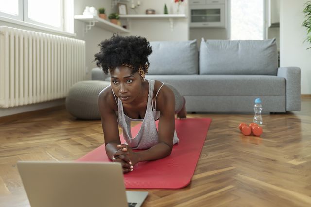 african american female in sportswear doing plank exercises