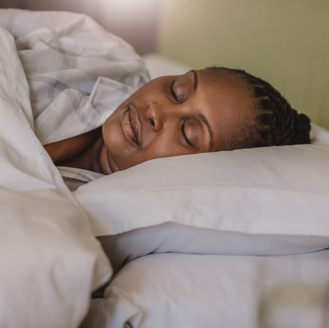 best sleep sprays african american woman sleeping soundly in her bed at home