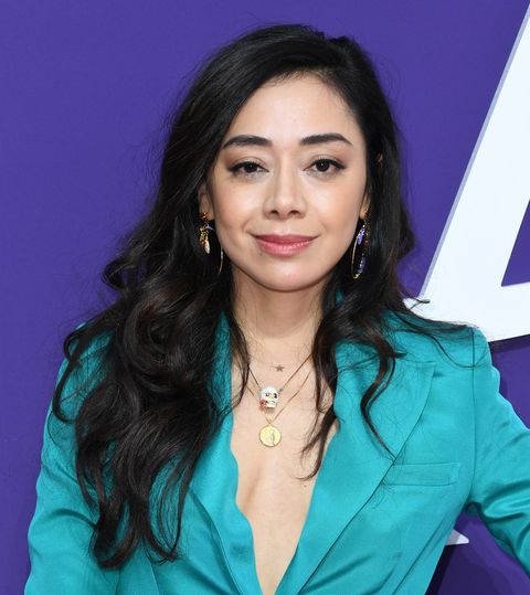 aimee garcia smiles at the addams family premiere in october 2019 wearing an aqua coloured jacket