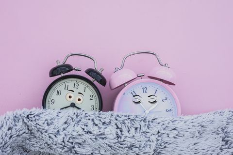 alarm clock female and male sleeping in bed