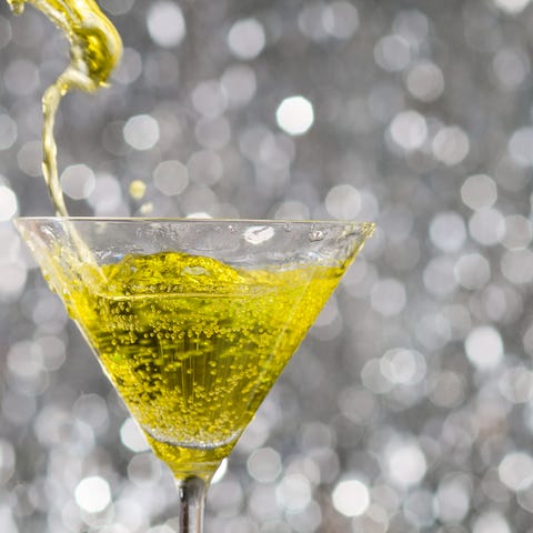 alcoholic cocktail over silver sparkling background yellow cocktail on grey background