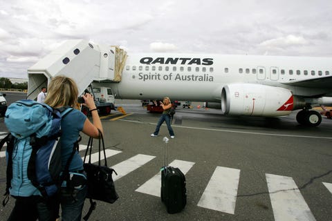 A tourist poses for a photo before depar...