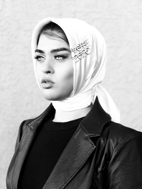 a black and white portrait of amani on her hijab, she wears two bedazzled hair clips that read "vote 2020"