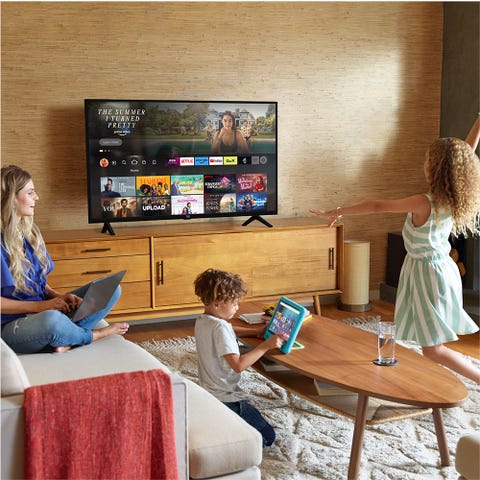amazon fire tv series 2 on tv stand with family playing in front of it