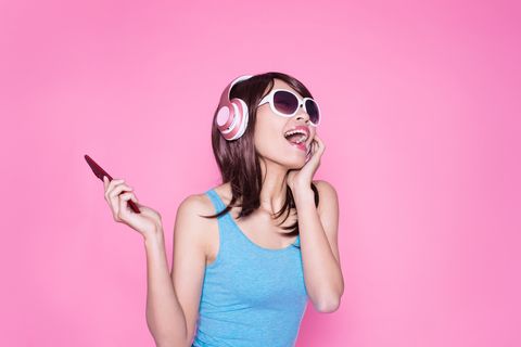 woman listening to music on the phone, with wireless headphones
