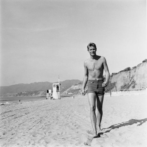 1960年、砂浜を歩く俳優トロイ・ドナヒュー。