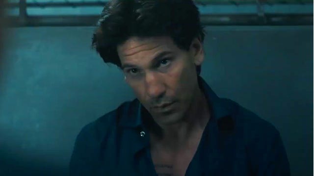 jon bernthal in american gigolo in a blue shirt in an interrogation room