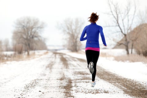 An Athletic woman jogging in the winter.