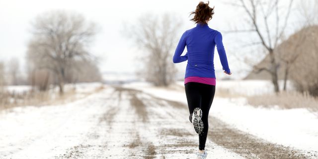an athletic woman jogging in the winter