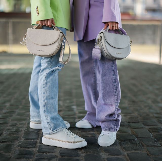 two women wear white sneakers in street style cologne february 2022