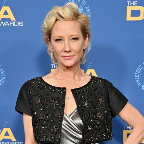 anne heche, a woman standing with hand on hip, wearing a silver dress and black cardigan