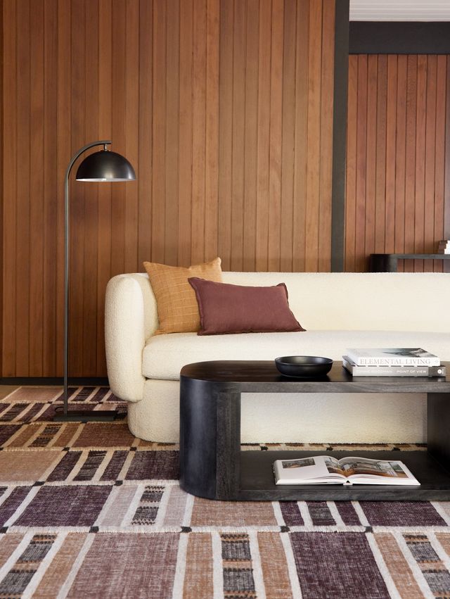brown and mauve rug under a sofa