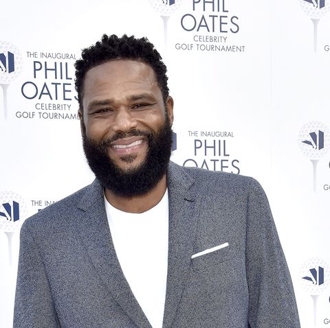 anthony anderson wearing a grey suit with white tshirt and trainers