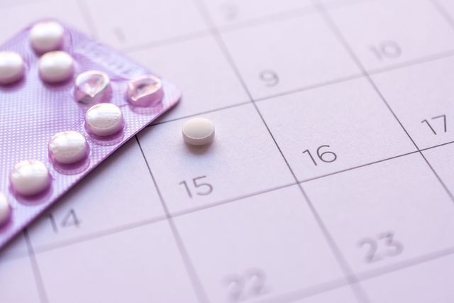 birth control pill with date of calendar background, health care and medicine concept