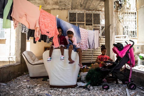 kids sitting by a colorful clothing line crying