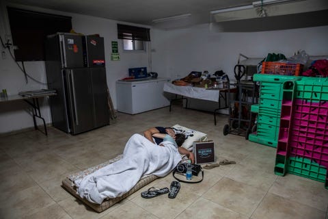 couple snuggling on a mattress in a barren room