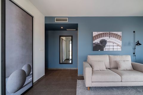salón con sofá beige, paredes azules y fotografías en blanco y negro