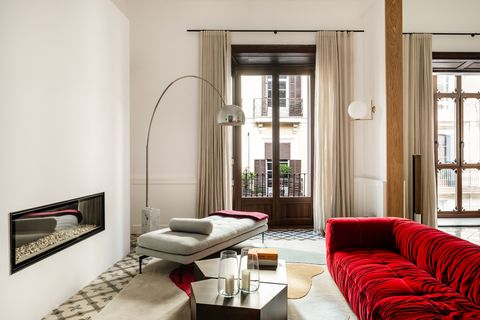 salón con sofá de terciopelo rojo y diván gris
