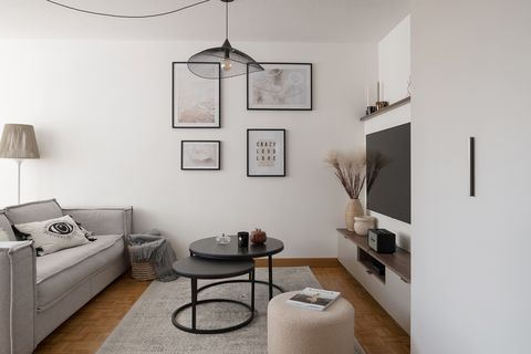 salón moderno con sofá gris y mesas nido negras