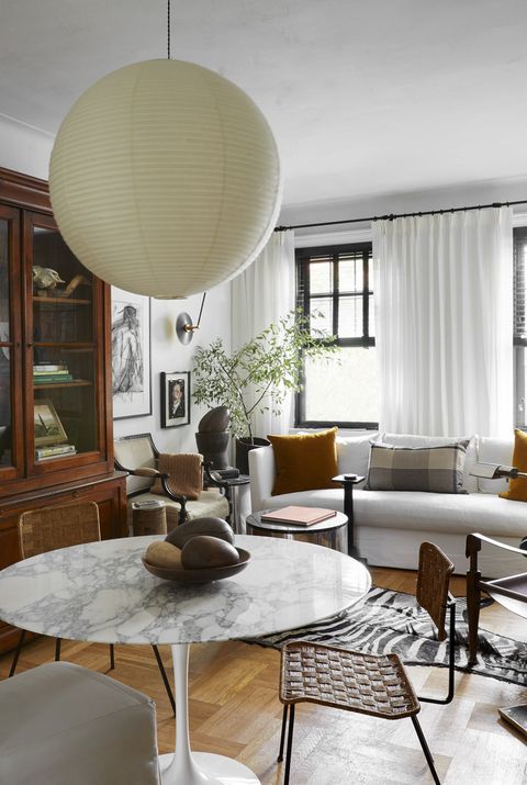 david frazier nyc apartment
living room
with limited space in this new york
city apartment, designer david frazier
divided the living room into two
distinct zones lounging and eating
paint simply white, benjamin
moore dining table eero saarinen,
knoll chairs lee industries
slipper vintage french rattan
vintage kaare klint safari
pendant isamu noguchi bookcase
scott antique markets ram’s
head vintage, high point market