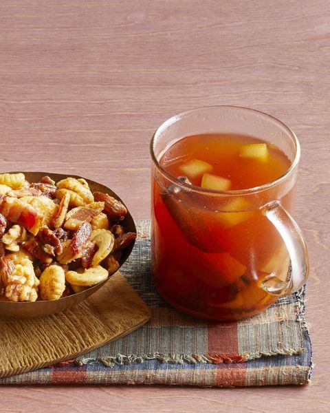 mulled cider with bourbon in glass mug with nuts on the side