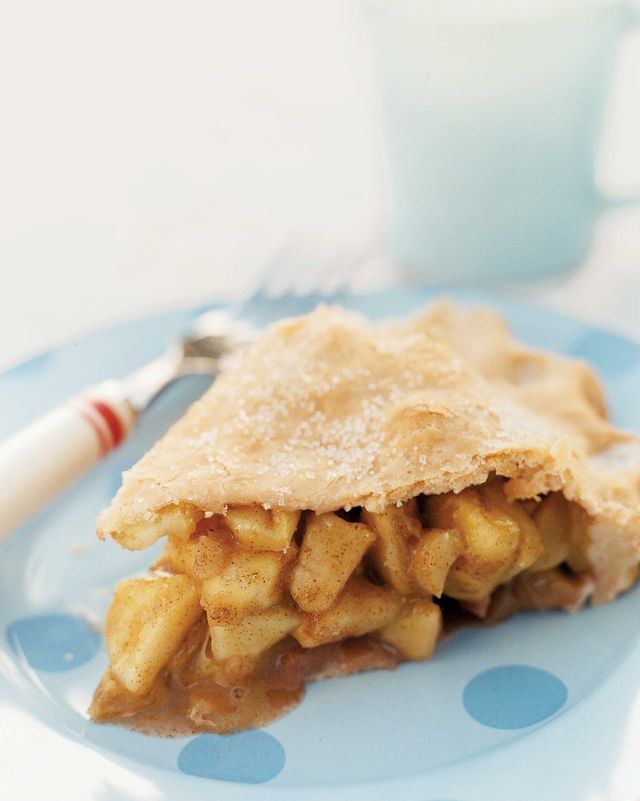 a slice of double crust apple pie on a light blue plate with a fork