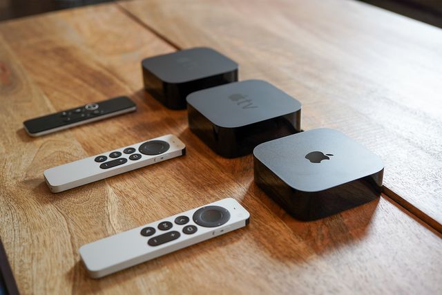 3 apple tv's with remotes on a table
