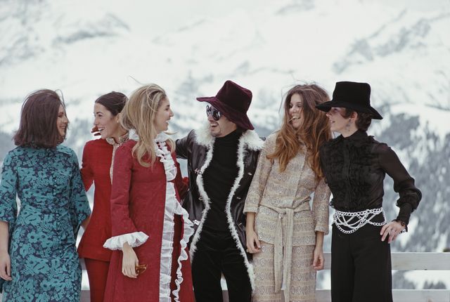 gruppo di donne e uomini ben vestiti si concedono una pausa dalle piste per un apres ski