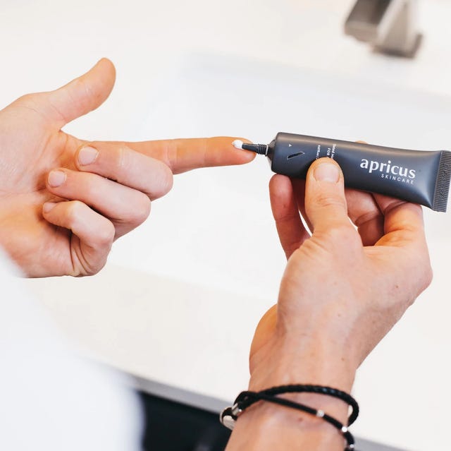 person using a tube of apricus skincare tinted moisturizer