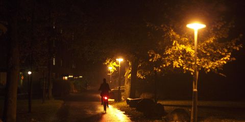 Cyclist riding alone on the street in the rain with a bike light
