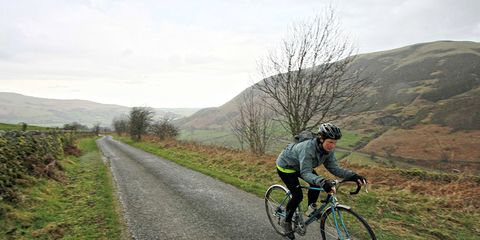 cyclist riding down country road