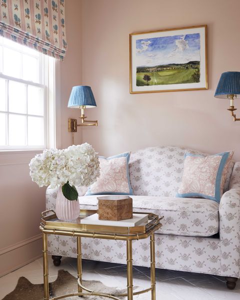 pink painted walls, gold coffee table, blue sconces