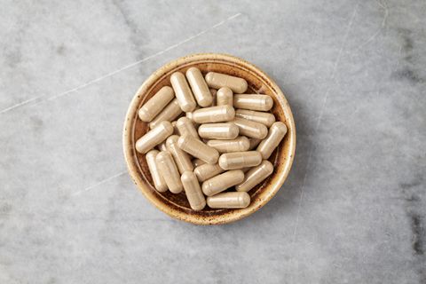 ashwagandha withania somnifera capsules concept for a healthy dietary supplementation bright stone background top view copy space