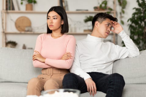 asian couple after quarrel not talking sitting offended at home