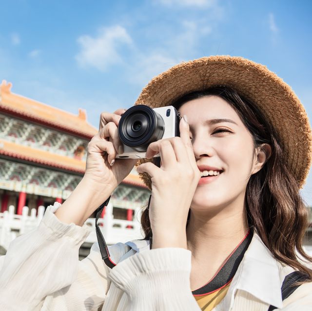 asian female traveler photographing temples at  Asia