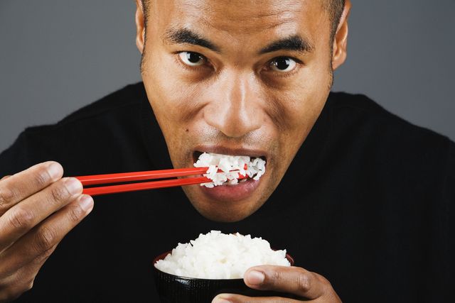un hombre comiendo arroz blanco