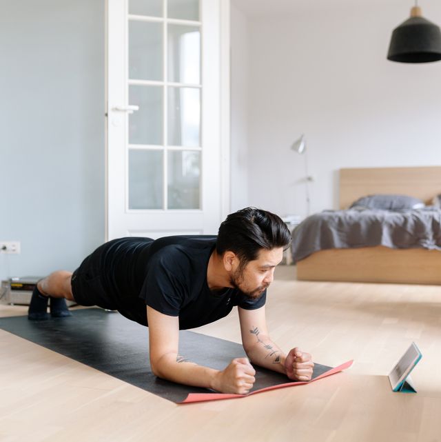 Asian man uses digital tablet to lean plank position