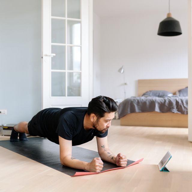 Asian man uses digital tablet to lean plank position
