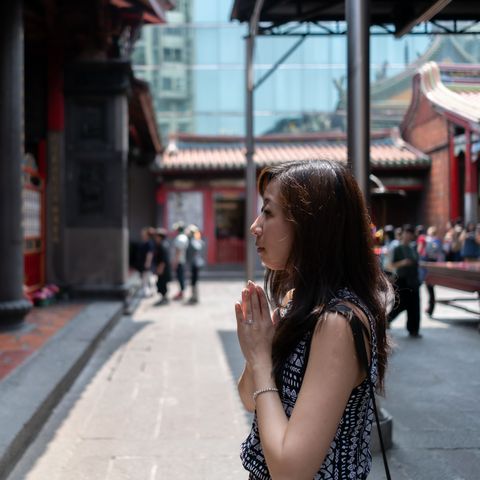 asian tourist praying at temple, taipei, taiwan