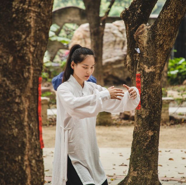 asian woman practicing tai chi outdoor